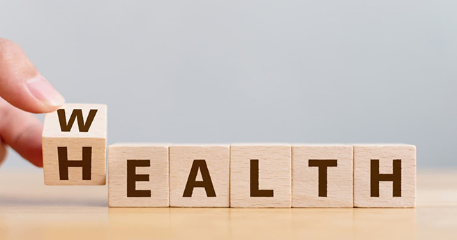 Hand flip wooden cube with word wealth to health. Investment in life insurance and healthcare concept